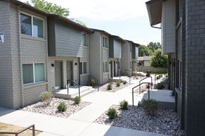 Vernal apartment for rent - A row of modern townhouses with grey siding and white trim.