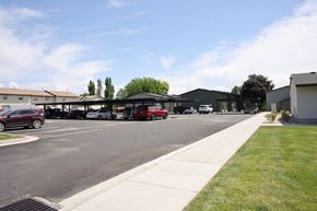 Vernal apartment for rent - A parking lot with cars and a building in the background.