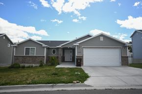 Magna apartment for rent - a gray house with a driveway and a garage door