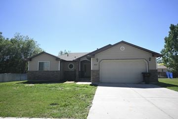 Myton apartment for rent - a beige house with a garage door and a lawn