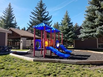 Park City apartment for rent - a playground with a blue and red swing set in front of a house