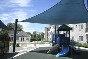 Ogden apartment for rent - a playground with a blue swing set and a shade canopy