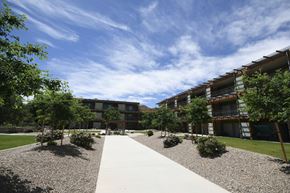 Moab apartment for rent - a courtyard with trees and a sidewalk in front of an apartment building