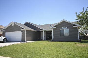 Toquerville apartment for rent - a gray house with a lawn and a garage