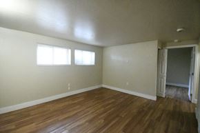 Price apartment for rent - an empty living room with a wooden floor and white walls