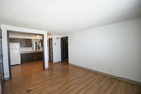 Blanding apartment for rent - an empty living room with wood floors and a kitchen