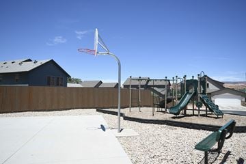Moab apartment for rent - a playground with a swing set and a basketball hoop in front of a house