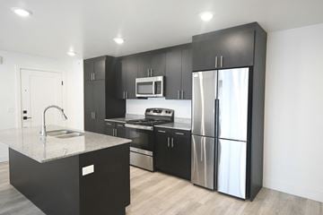 Park City apartment for rent - a kitchen with black cabinets and stainless steel refrigerator