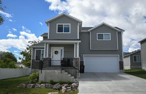 Magna apartment for rent - a gray house with a driveway and a garage door