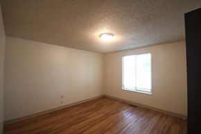 Roosevelt apartment for rent - an empty living room with wood floors and a window