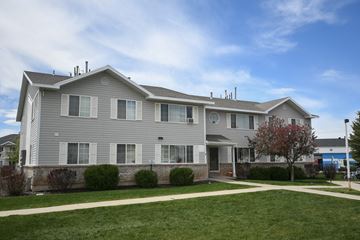 Kamas apartment for rent - a gray house with a sidewalk in front of a lawn