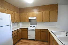 Cedar City apartment for rent - an empty kitchen with white appliances and wooden cabinets