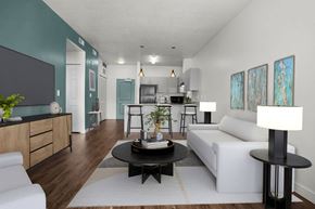 Salt Lake City apartment for rent - A living room with a white couch, a black coffee table, and a white floor lamp.