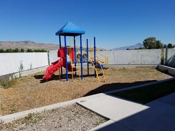 Tremonton apartment for rent - a playground in a yard with a blue and red swing set