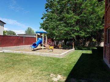 Vernal apartment for rent - a playground in the backyard of a house with a blue slide