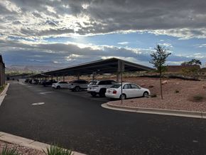 Moab townhouse for rent - A parking lot with cars and a building in the background.