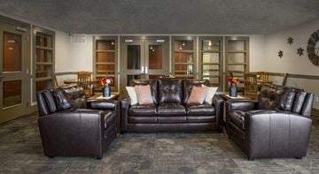 Heber City apartment for rent - a living room with leather couches and chairs and a dining area