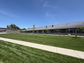 Smithfield apartment for rent - A building with a grey roof and a green lawn in front.