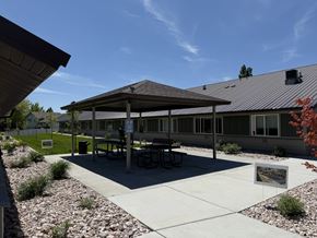 Smithfield apartment for rent - A pavilion with a picnic table is surrounded by gravel and grass.