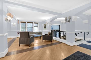 Buffalo apartment for rent - A living room with a grey couch and a black chair.