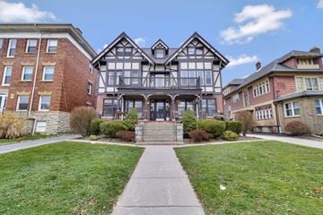 Buffalo apartment for rent - A large house with a black and white facade is in the center of the image.