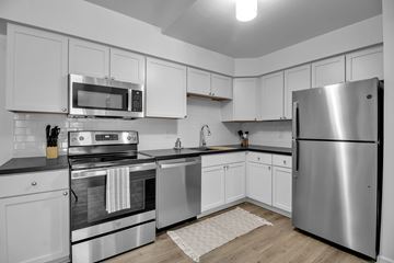 Buffalo apartment for rent - A modern kitchen with stainless steel appliances and white cabinets.