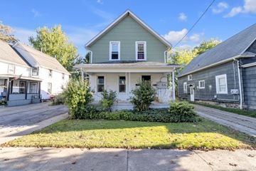 North Tonawanda apartment for rent - A green house with a white door and windows is in the foreground.
