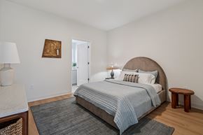 Cincinnati apartment for rent - A bedroom with a large bed and a small table at 7 West 7th Apartments, Cincinnati, OH