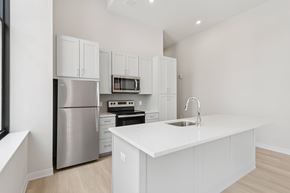 Pittsburgh apartment for rent - A modern kitchen with white cabinets and stainless steel appliances at LiveWell Apartments, Pittsburgh 15222