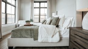 Fort Wayne apartment for rent - A bedroom with a bed covered in a green and white comforter. at The Pearl, Fort Wayne, IN