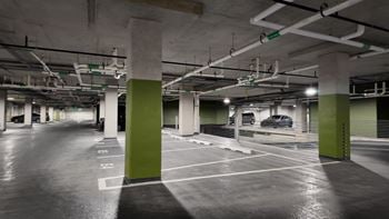 A parking garage with green pillars and white ceiling.