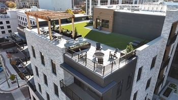 A modern building with a green roof and a balcony.