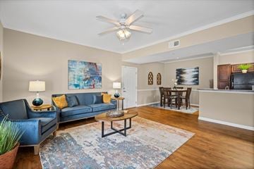 Mobile apartment for rent - A living room with a blue couch and a painting on the wall.