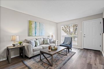 Mobile apartment for rent - A living room with a grey couch, a wooden coffee table, and a painting on the wall.