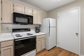 Tuscaloosa apartment for rent - A kitchen with a white oven and black microwave.