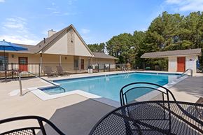 Pelham apartment for rent - A pool area with a blue pool and a house in the background.