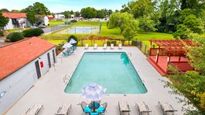 Huntsville apartment for rent - A large swimming pool surrounded by lounge chairs and umbrellas.