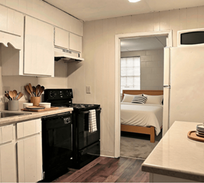 Tuscaloosa townhouse for rent - A small kitchen with a black stove and white cabinets.
