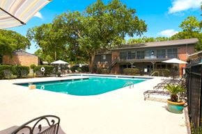 Mobile apartment for rent - A large outdoor swimming pool surrounded by trees and a building.