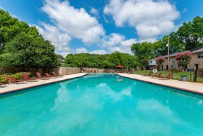 Huntsville apartment for rent - A large swimming pool surrounded by trees and lawn chairs.