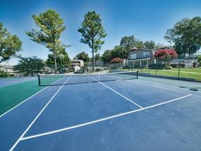 Huntsville apartment for rent - a tennis court with trees and a house in the background
