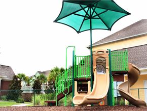 Mobile apartment for rent - playground being shaded by a blue umbrella