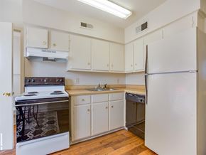 Tuscaloosa townhouse for rent - a kitchen with white cabinets and appliances and a refrigerator
