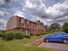 Tuscaloosa townhouse for rent - A blue car is parked in front of a brick house.