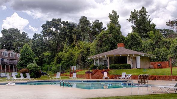 Tuscaloosa townhouse for rent - A pool with chairs around it and a house in the background.