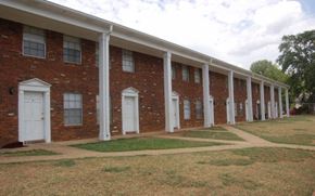Tuscaloosa townhouse for rent - A long row of red brick houses with white doors and windows.