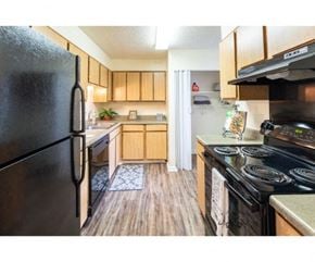 Flowood apartment for rent - a kitchen with black appliances and wooden cabinets