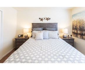 Flowood apartment for rent - a bedroom with a bed and a painting on the wall