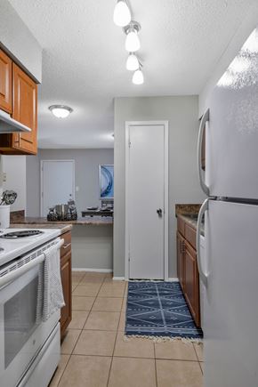 Pelham apartment for rent - A kitchen with a white stove top oven and a white refrigerator.