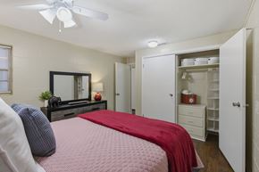 Tuscaloosa apartment for rent - A bedroom with a bed, dresser, and a ceiling fan.
